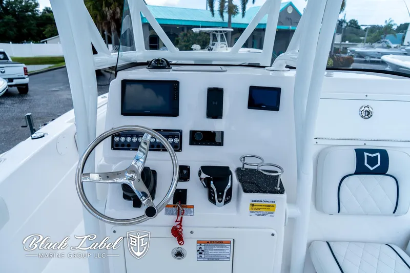 Slide: The Image of 2024 Sea Fox 248 Side Console boat dashboard with steering wheel and electronic controls. - 15