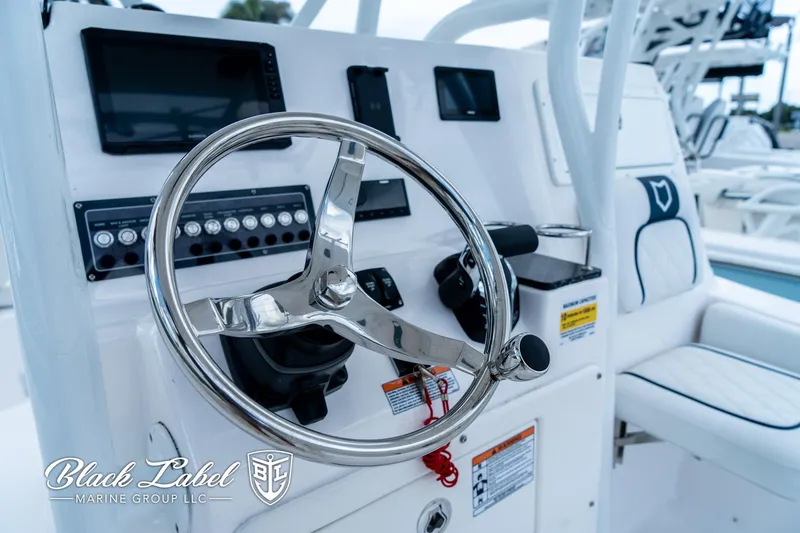 Slide: The Image of 2024 Sea Fox 248 Side Console boat dashboard with steering wheel and controls. - 19