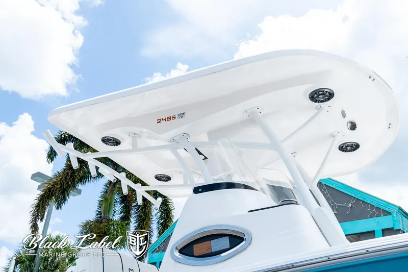 Slide: The Image of 2024 Sea Fox 248 Side Console boat with T-top, viewed from below, against a blue sky. - 3