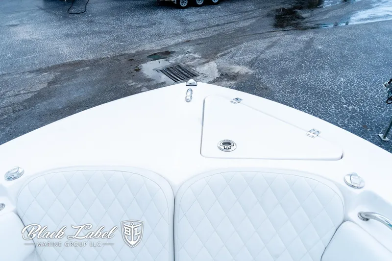 Slide: The Image of 2024 Sea Fox 248 Side Console boat with white quilted seating, docked on a wet surface. - 10