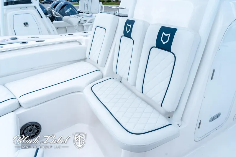 Slide: The Image of 2024 Sea Fox 248 Side Console boat seating with white and blue cushioned design. - 11