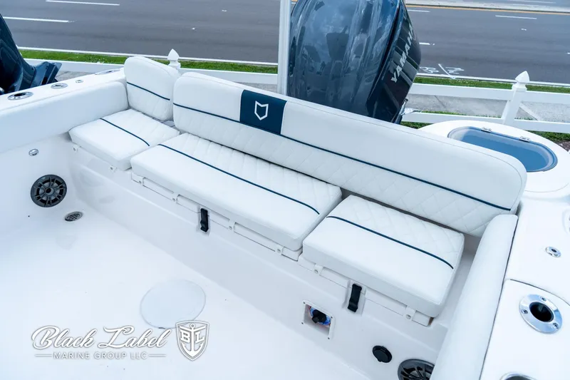 Slide: The Image of 2024 Sea Fox 248 Side Console boat with white cushioned seating and outboard motor. - 24