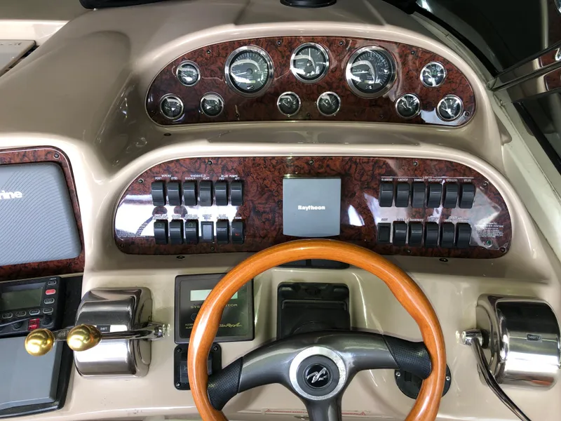 Slide: The Image of 2002 Sea Ray 360 Sundancer helm with gauges, controls, and Raytheon navigation system. - 23