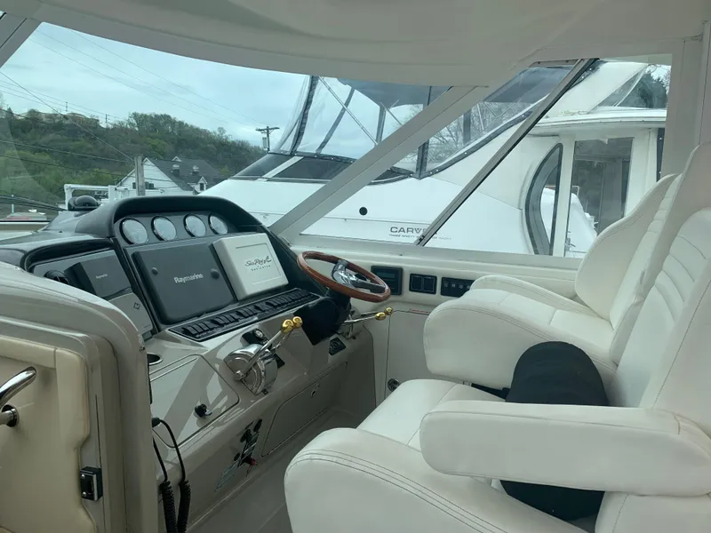 Slide: The Image of 2005 Sea Ray 390 Motor Yacht helm with white leather seats and modern navigation equipment. - 11