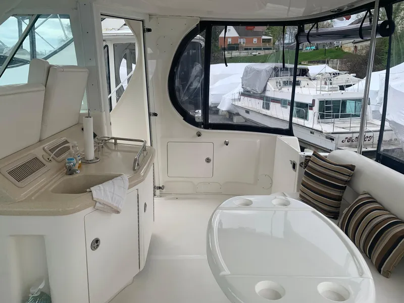 Slide: The Image of 2005 Sea Ray 390 Motor Yacht interior with kitchenette and seating area. - 17