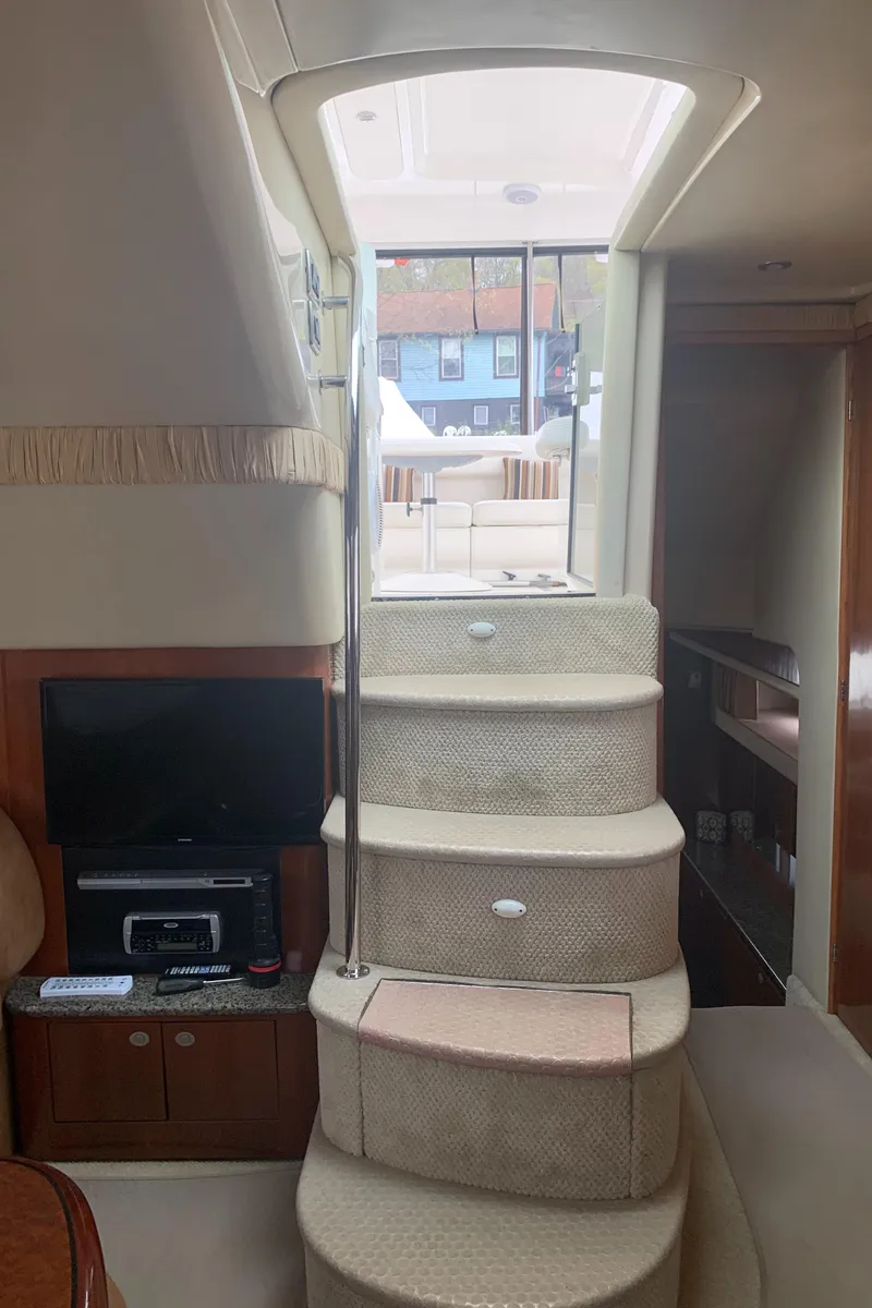 Slide: The Image of Interior view of 2005 Sea Ray 390 Motor Yacht with carpeted stairs and entertainment system. - 19