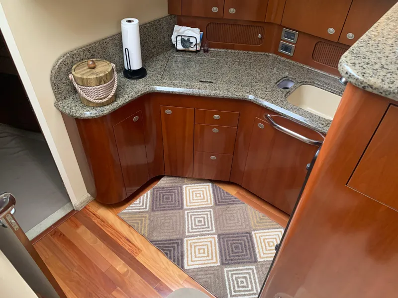 Slide: The Image of 2005 Sea Ray 390 Motor Yacht kitchen with granite countertops and wooden cabinetry. - 21
