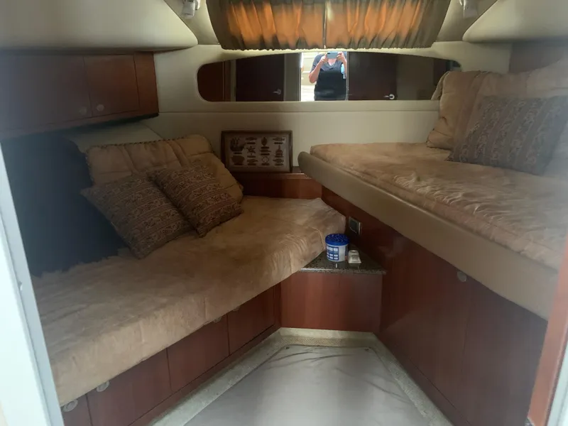 Slide: The Image of Interior cabin of a 2005 Sea Ray 390 Motor Yacht with cozy bedding and wooden cabinets. - 22