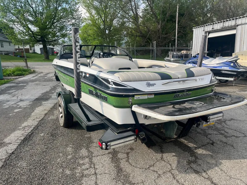 Slide: The Image of 2014 Malibu Response TXi boat on trailer in outdoor setting. - 2