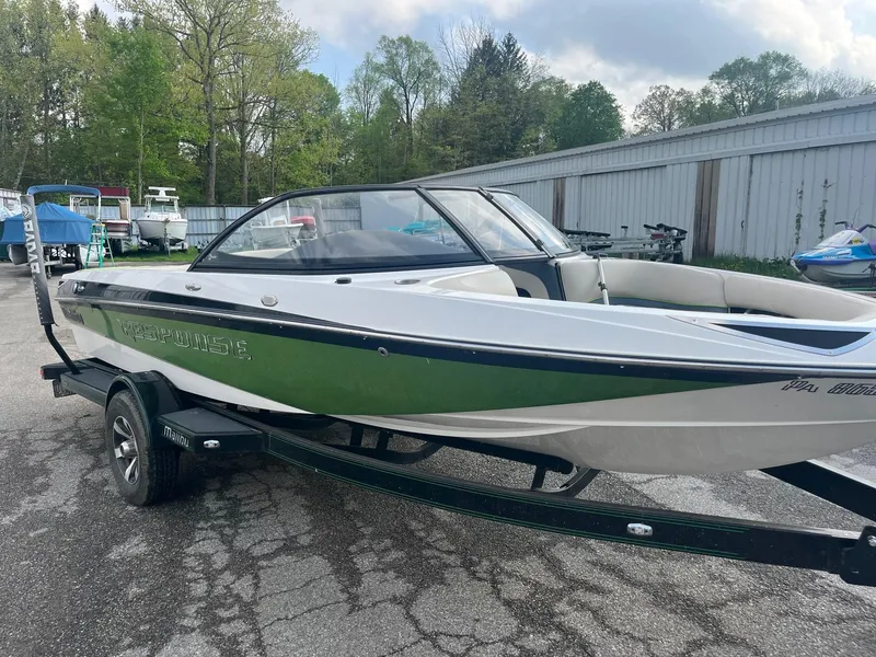 Slide: The Image of 2014 Malibu Response TXi boat on a trailer in a parking lot. - 6