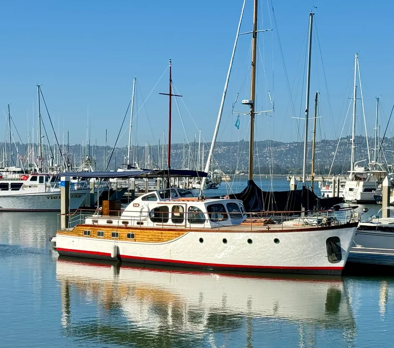 The Image of Classic 1966 Rampart 48 yacht docked in a marina, reflecting on calm water. - 0