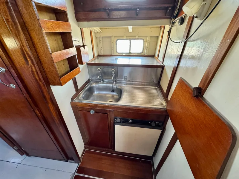 Slide: The Image of 1966 Rampart 48 boat interior with wooden furnishings and blue bedding. - 11