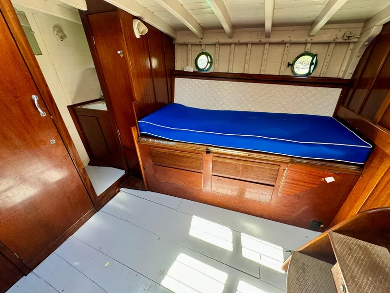 Slide: The Image of Interior of 1966 Rampart 48 boat with wooden furnishings and blue cushioned seating. - 13