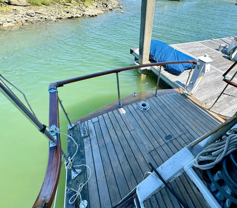 Slide: The Image of Wooden deck of a 1966 Rampart 48 boat docked at a marina. - 17