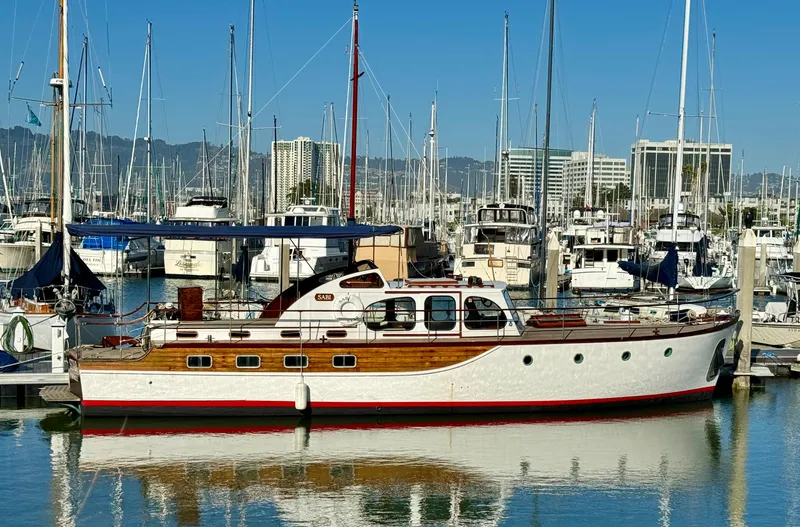Slide: The Image of Classic 1966 Rampart 48 yacht docked in a marina, featuring wooden details and a blue canopy. - 2