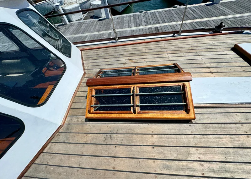 Slide: The Image of 1966 Rampart 48 yacht docked at marina, featuring wooden deck and classic design. - 20