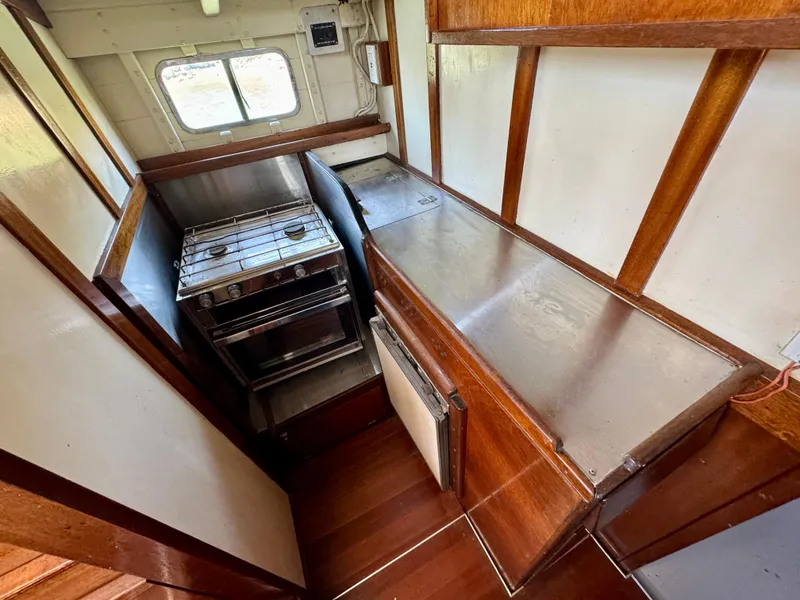 Slide: The Image of Interior of a 1966 Rampart 48 yacht with wooden flooring and seating area. - 9