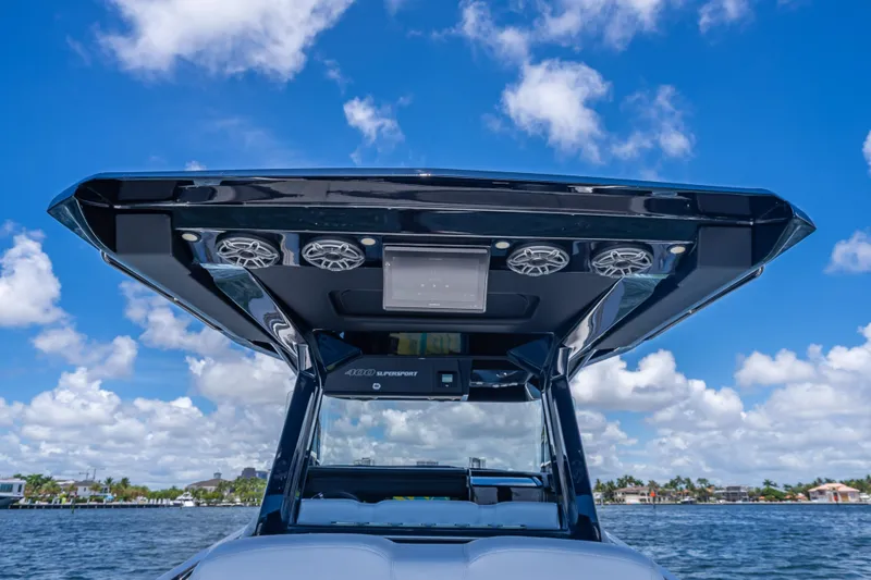 Slide: The Image of 2024 Nor-Tech 400 Supersport boat with sleek design and advanced audio system under blue sky. - 18