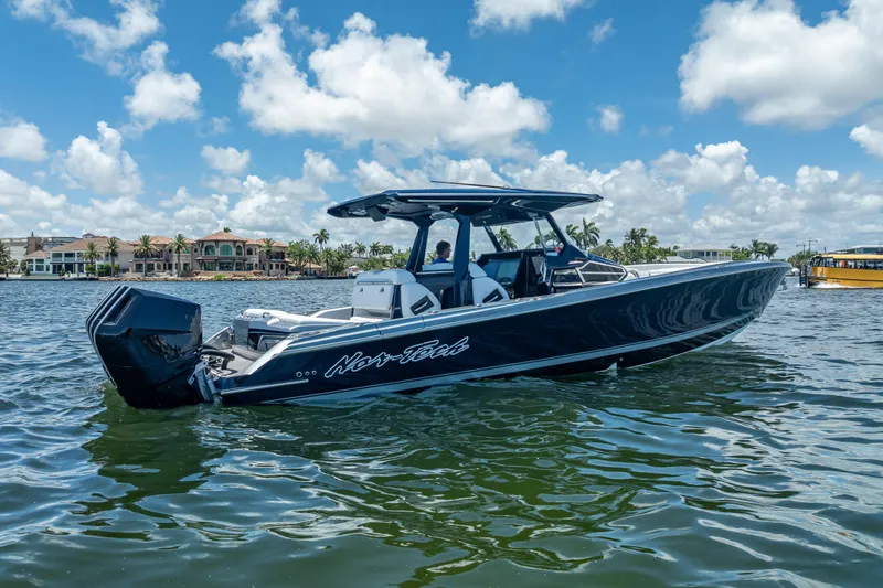 Slide: The Image of 2024 Nor-Tech 400 Supersport boat on water, clear sky, luxury waterfront homes. - 2