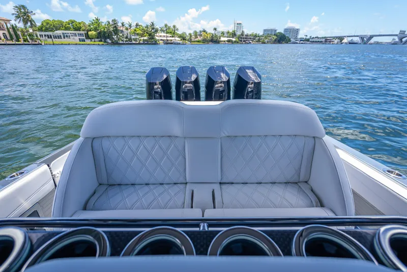 Slide: The Image of 2024 Nor-Tech 400 Supersport boat with luxurious seating and powerful engines on a scenic waterway. - 20