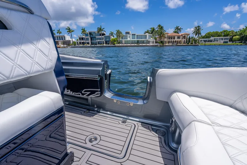 Slide: The Image of 2024 Nor-Tech 400 Supersport boat interior with luxurious seating, overlooking waterfront homes. - 25