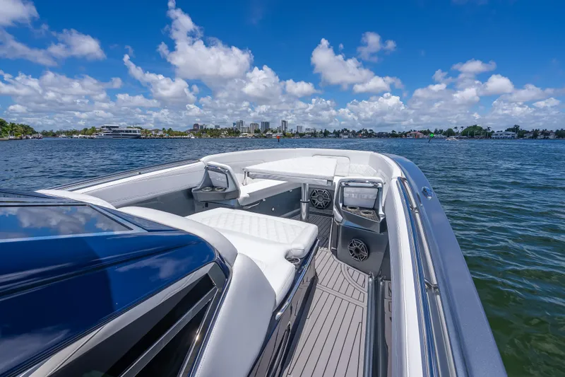 Slide: The Image of 2024 Nor-Tech 400 Supersport boat on water, featuring luxurious seating and clear blue skies. - 33