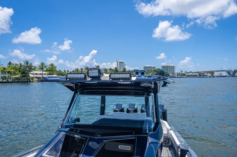 Slide: The Image of 2024 Nor-Tech 400 Supersport boat on water, clear sky, cityscape background. - 35