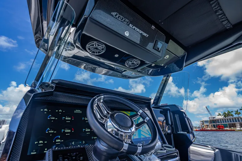 Slide: The Image of 2024 Nor-Tech 400 Supersport dashboard with steering wheel, digital displays, and blue sky background. - 44