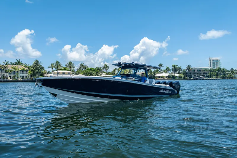 Slide: The Image of 2024 Nor-Tech 400 Supersport boat cruising on a sunny day with palm trees in the background. - 6