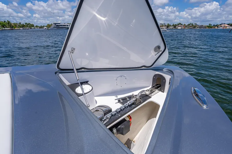 Slide: The Image of 2024 Nor-Tech 400 Supersport boat anchor compartment open on calm water. - 60