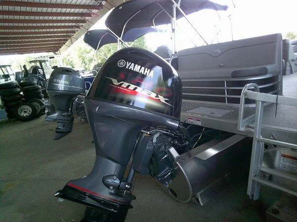 Slide: The Image of 2024 Bennington 208SLJ pontoon boat with Yamaha outboard motor in a covered storage area. - 6