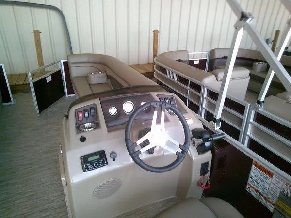 Slide: The Image of 2024 Bennington 21SXL pontoon boat interior with steering console and seating. - 6
