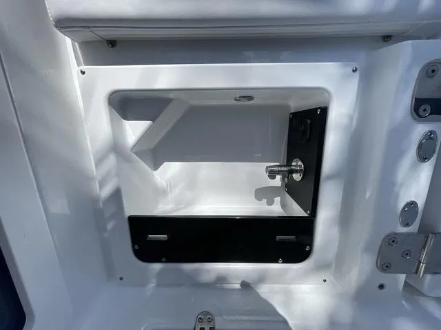 Slide: The Image of 2023 Blackfin 302CC storage compartment with latch and hinge details. - 13