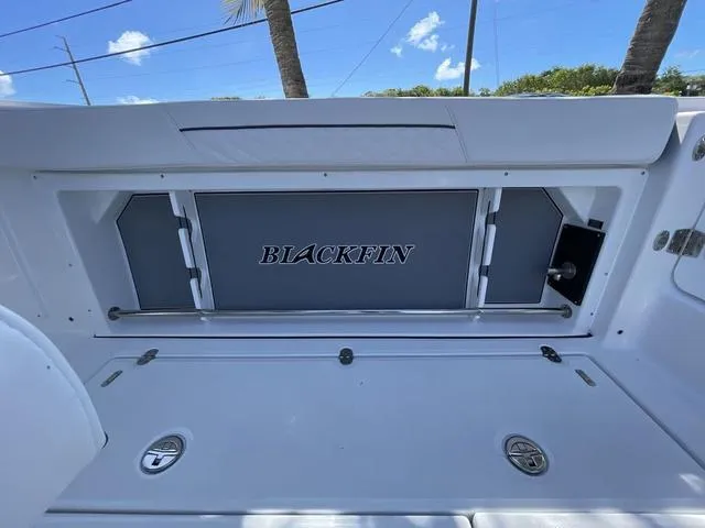 Slide: The Image of 2023 Blackfin 302CC boat interior with storage compartment and logo. - 16