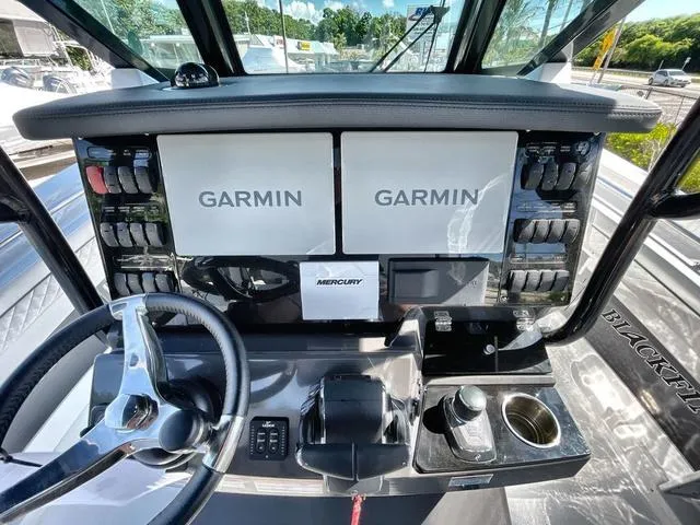Slide: The Image of 2023 Blackfin 302CC boat dashboard with dual Garmin displays and Mercury controls. - 3
