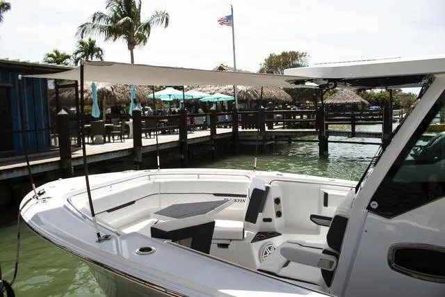 Slide: The Image of 2023 Blackfin 302CC boat docked near waterfront restaurant with palm trees. - 32