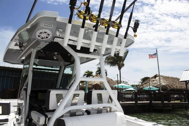 Slide: The Image of 2023 Blackfin 302CC boat with fishing rods docked at a marina. - 34