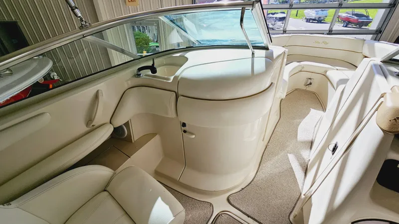 Slide: The Image of Interior of a 2000 Sea Ray 260 Bow Rider boat with white seating and carpet. - 11