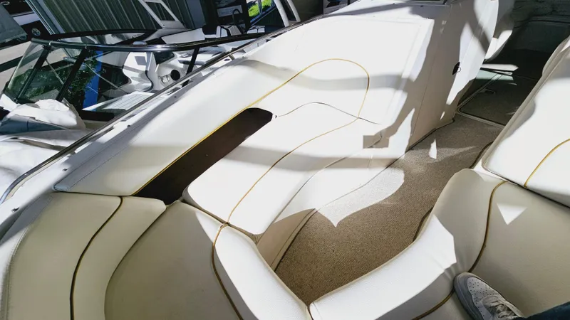 Slide: The Image of 2000 Sea Ray 260 Bow Rider interior with white leather seating and carpeted floor. - 16