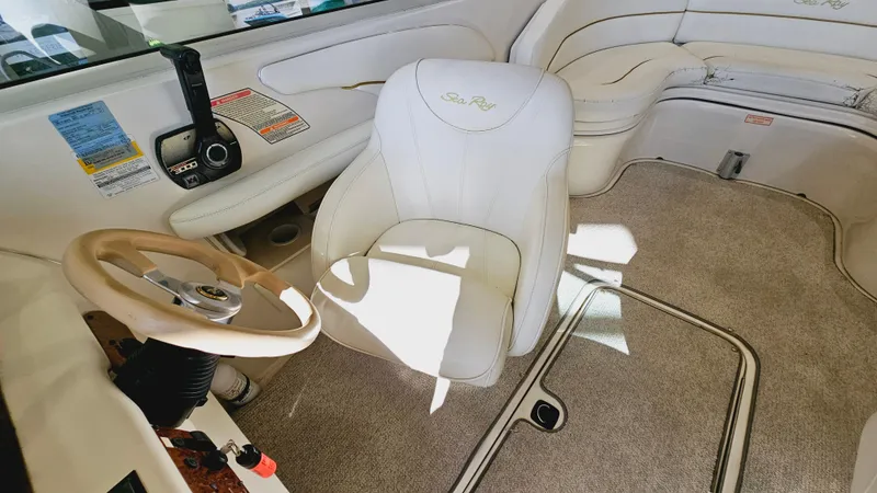 Slide: The Image of Interior of a 2000 Sea Ray 260 Bow Rider boat with white seating and beige carpet. - 9