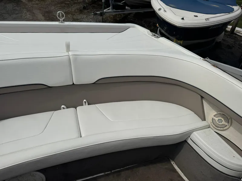Slide: The Image of White seating area on a 2000 Cobalt 252 boat, featuring clean upholstery and integrated speaker. - 11