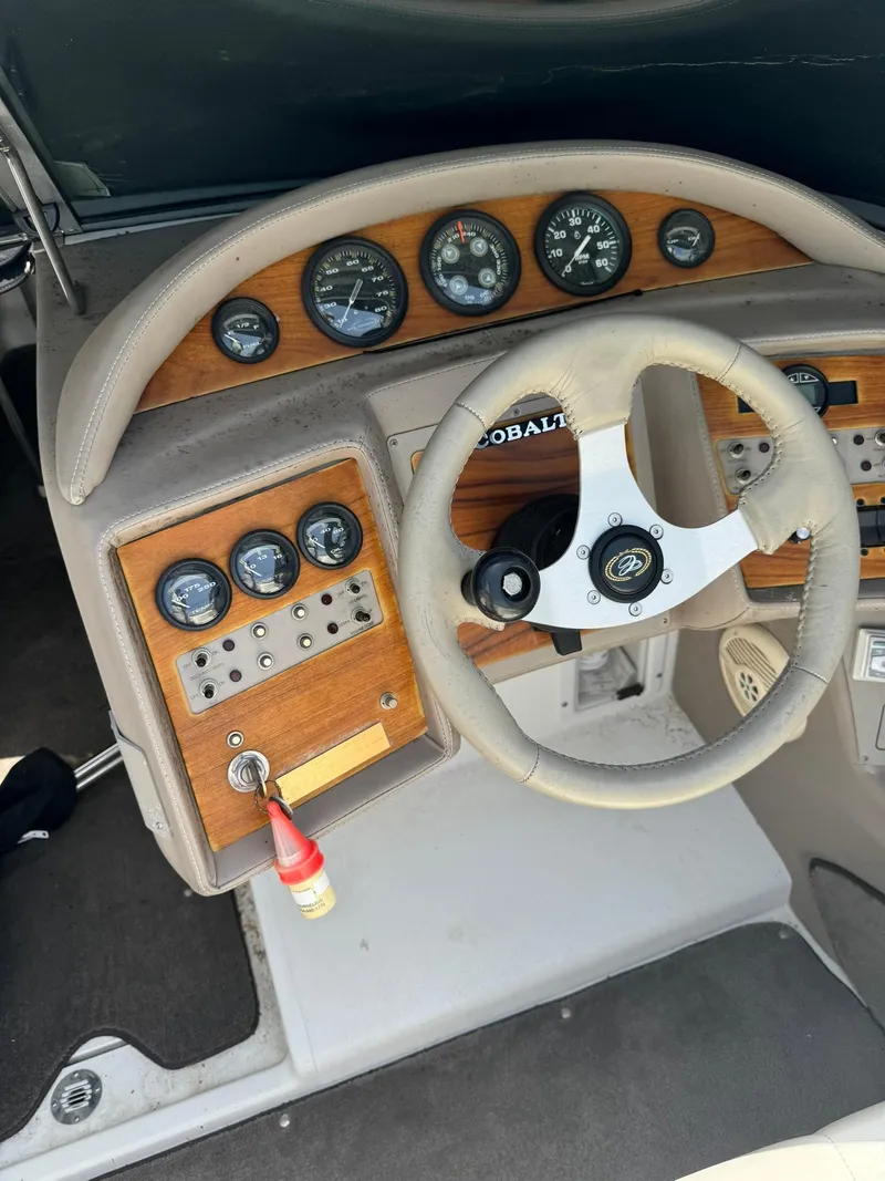 Slide: The Image of Dashboard of a 2000 Cobalt 252 boat with wooden paneling and steering wheel. - 14