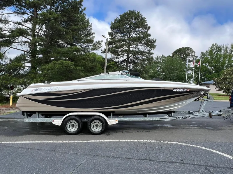 Slide: The Image of 2000 Cobalt 252 boat on a trailer in a parking lot. - 2