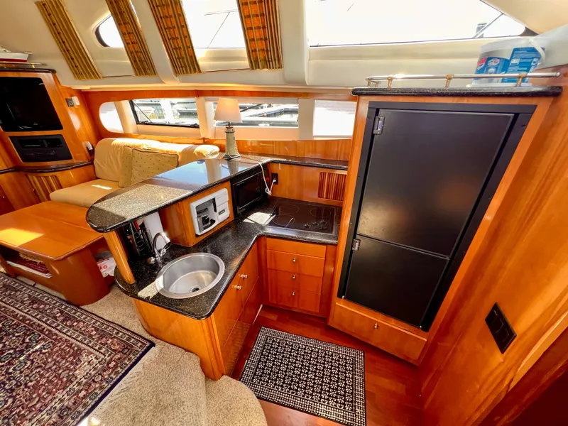 Slide: The Image of 2002 Carver 396 Motor Yacht interior with kitchen and seating area. - 16