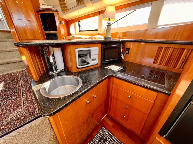 Slide: The Image of 2002 Carver 396 Motor Yacht kitchen with sink, microwave, and stove. - 17
