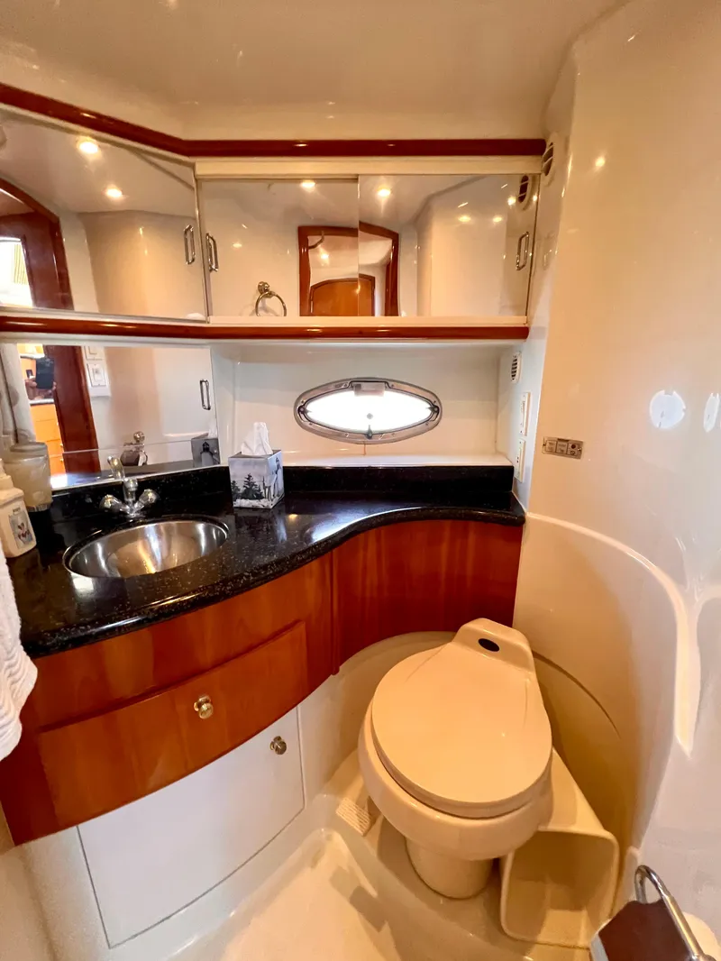 Slide: The Image of 2002 Carver 396 Motor Yacht bathroom with sink, toilet, and storage cabinets. - 19