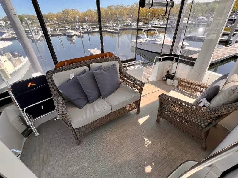 Slide: The Image of 2002 Carver 396 Motor Yacht interior with wicker seating and marina view. - 9