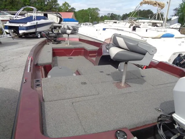 Slide: The Image of 1987 Venture Bass Boat 18 with gray carpeted deck and swivel seats in a marina. - 4