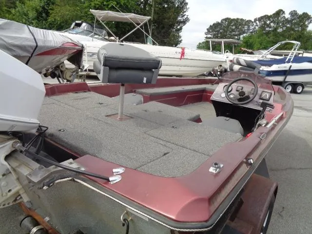 Slide: The Image of 1987 Venture Bass Boat 18, red and gray, docked with other boats. - 6