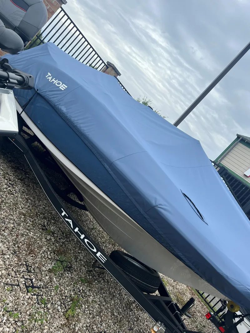 Slide: The Image of 2024 Tahoe 2150 boat with blue cover on trailer. - 1